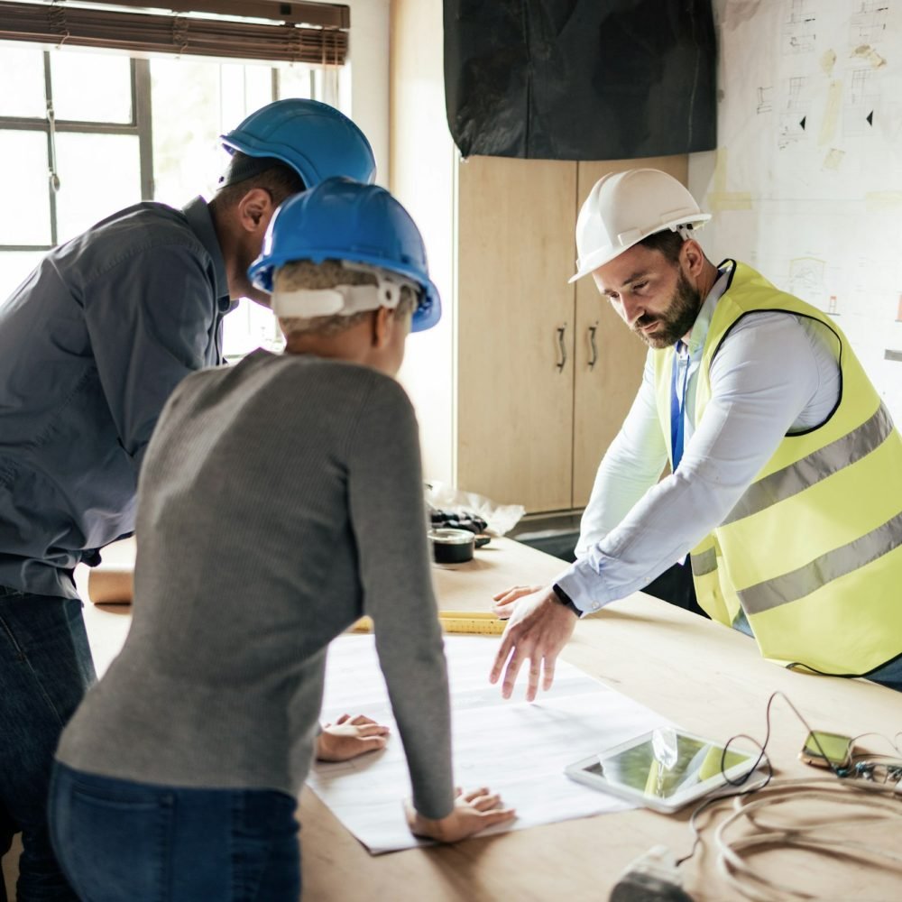 Construction workers, teamwork collaboration and blueprint planning in house, home or office buildi