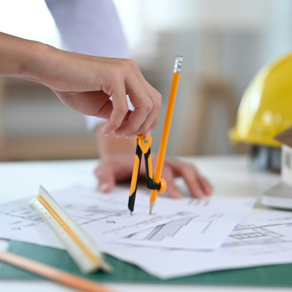 Cropped shot of Architect design working on blueprint in architect studio.